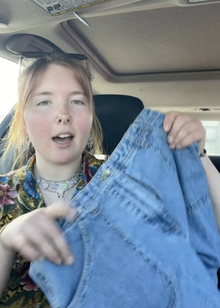 woman holding a pair of jeans